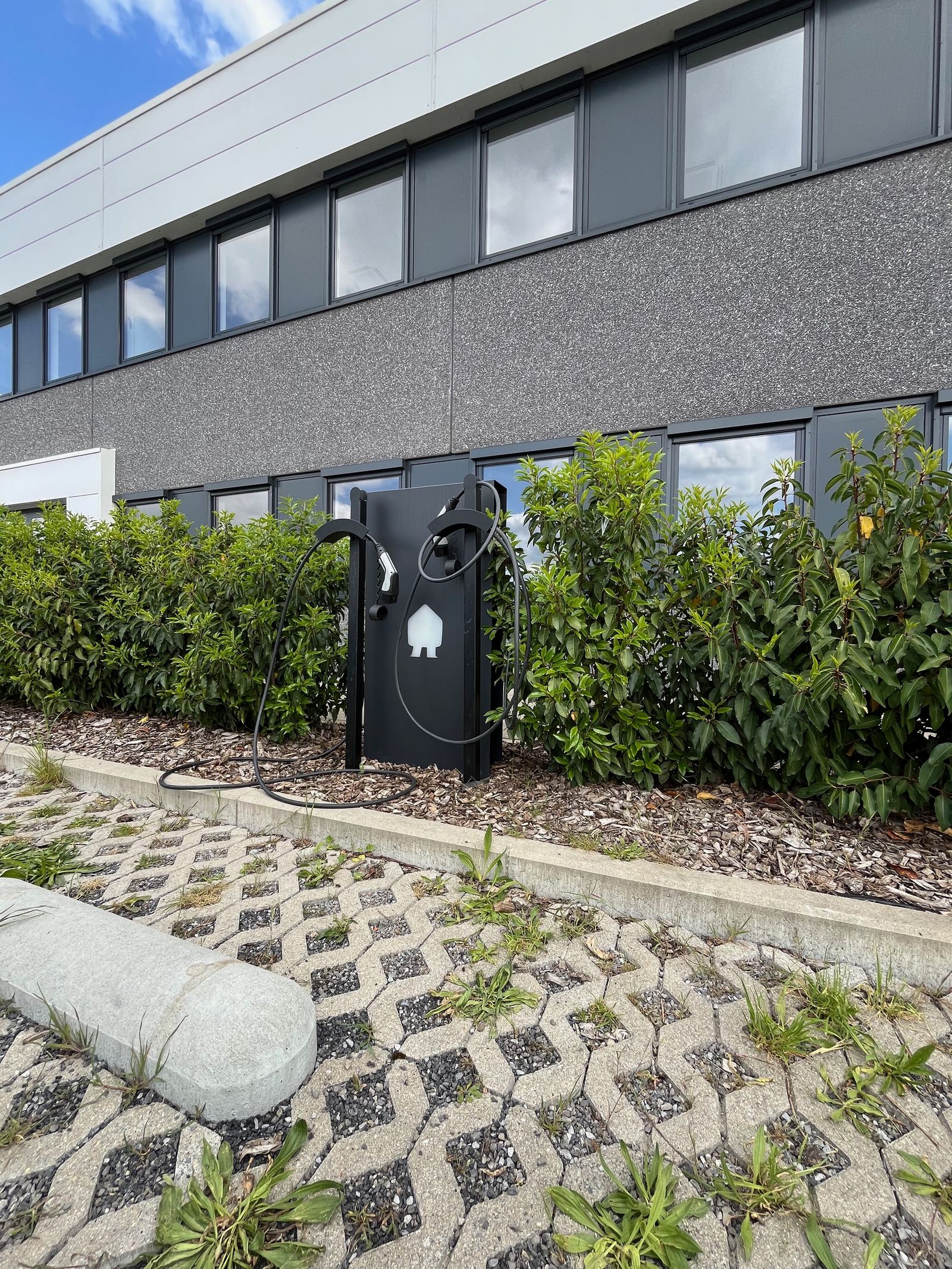 Borne de rechargement installée le long d'un bâtiment de bureaux