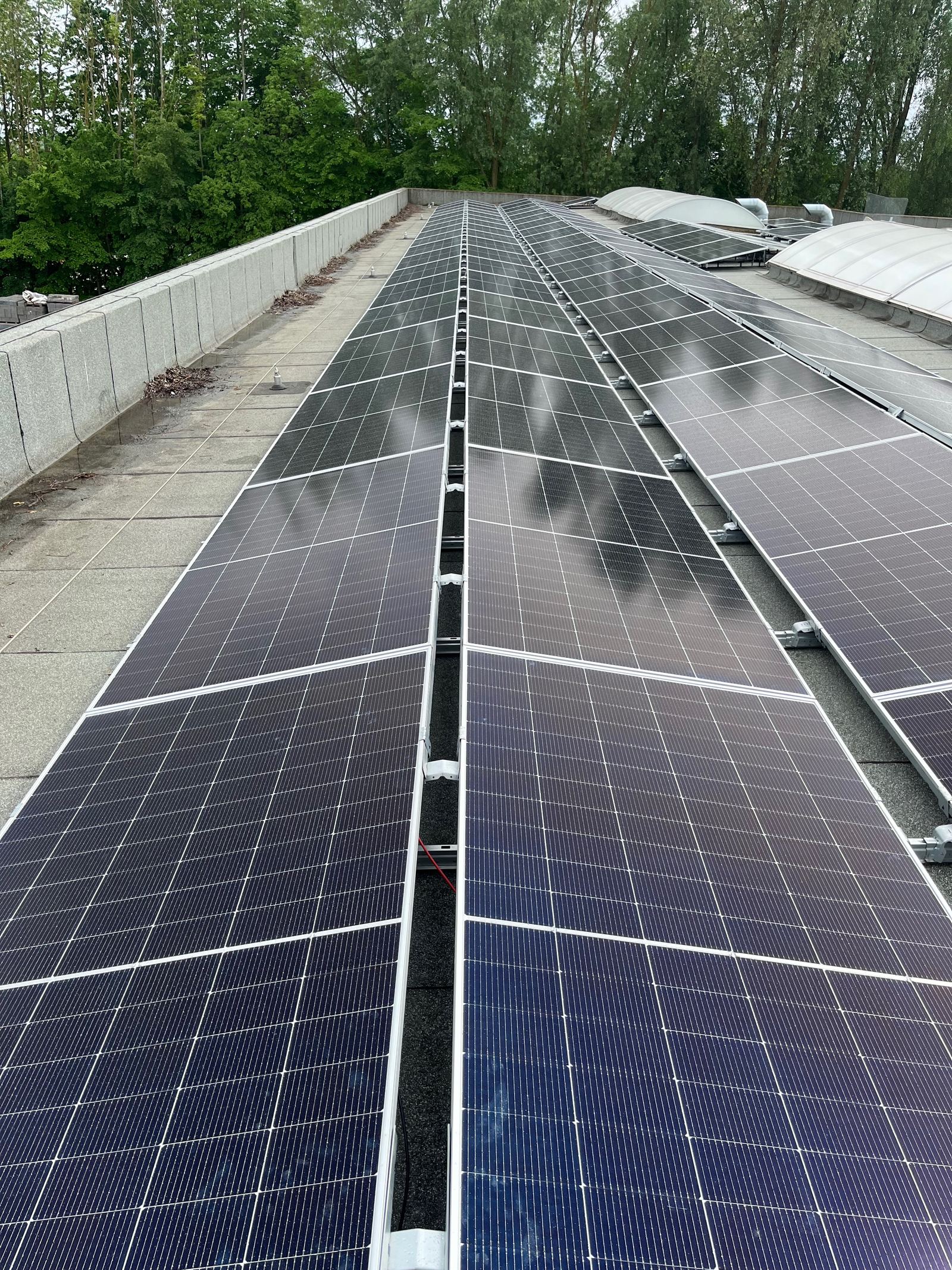 Longue rangée de panneaux photovoltaïques sur une toiture industrielle à Gembloux